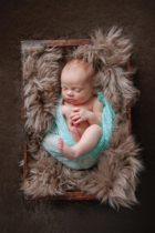 swaddled baby in box for newborn photography session